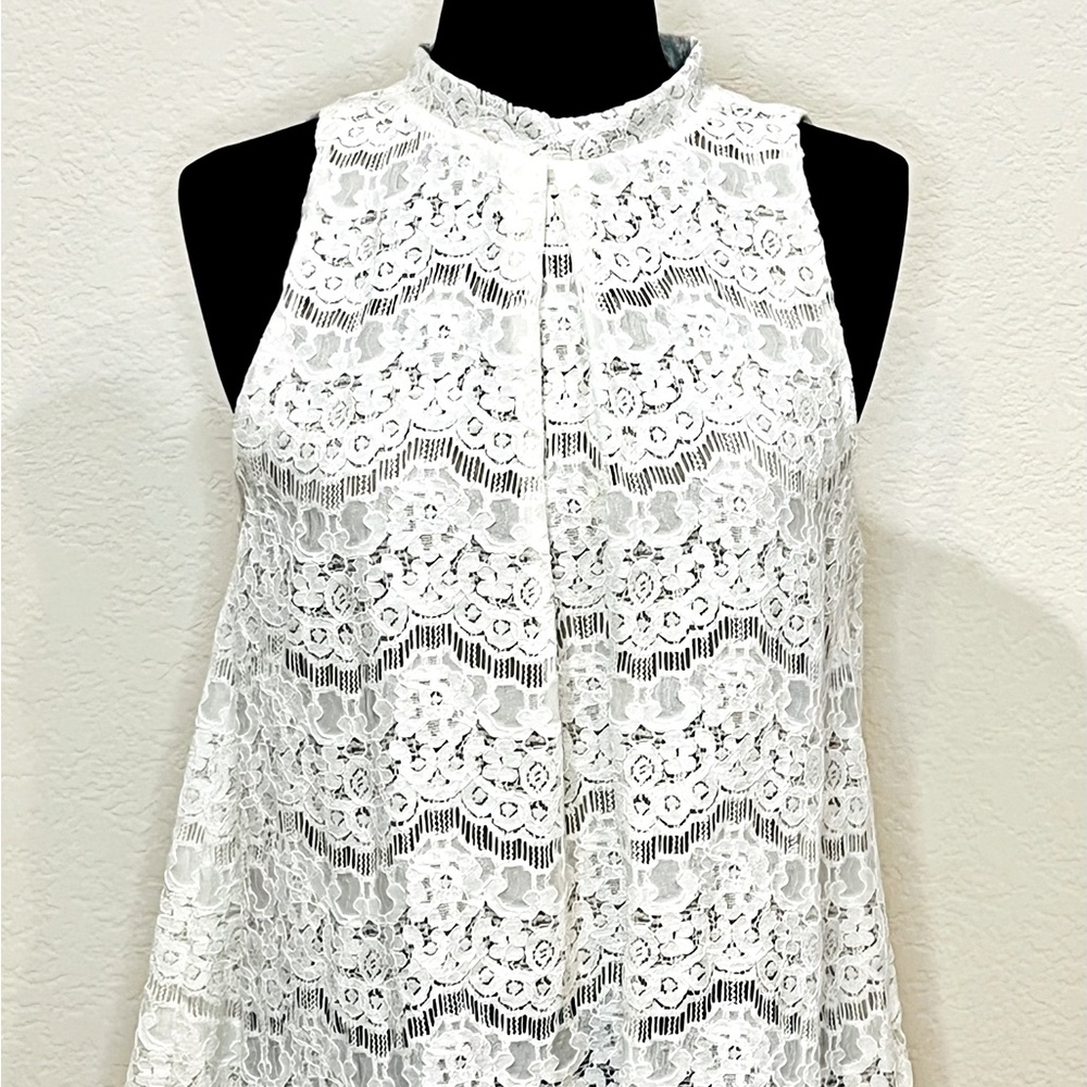Sleeveless off-white lace top with keyhole opening in back.